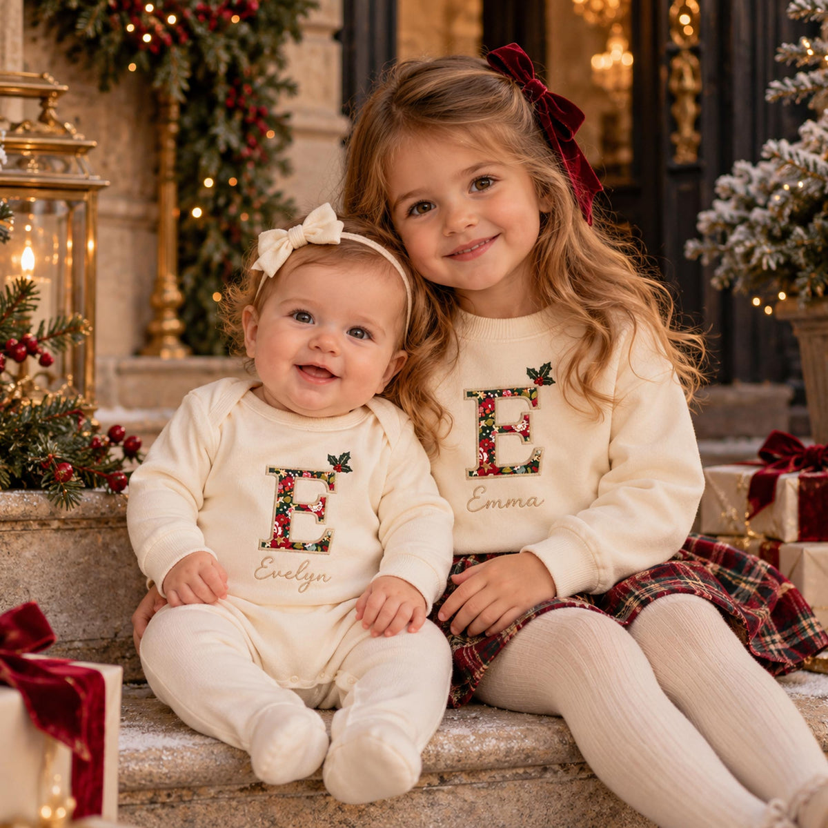 Oat Christmas baby romper with Liberty fabric initial and embroidered holly, sibling lifestyle photo
