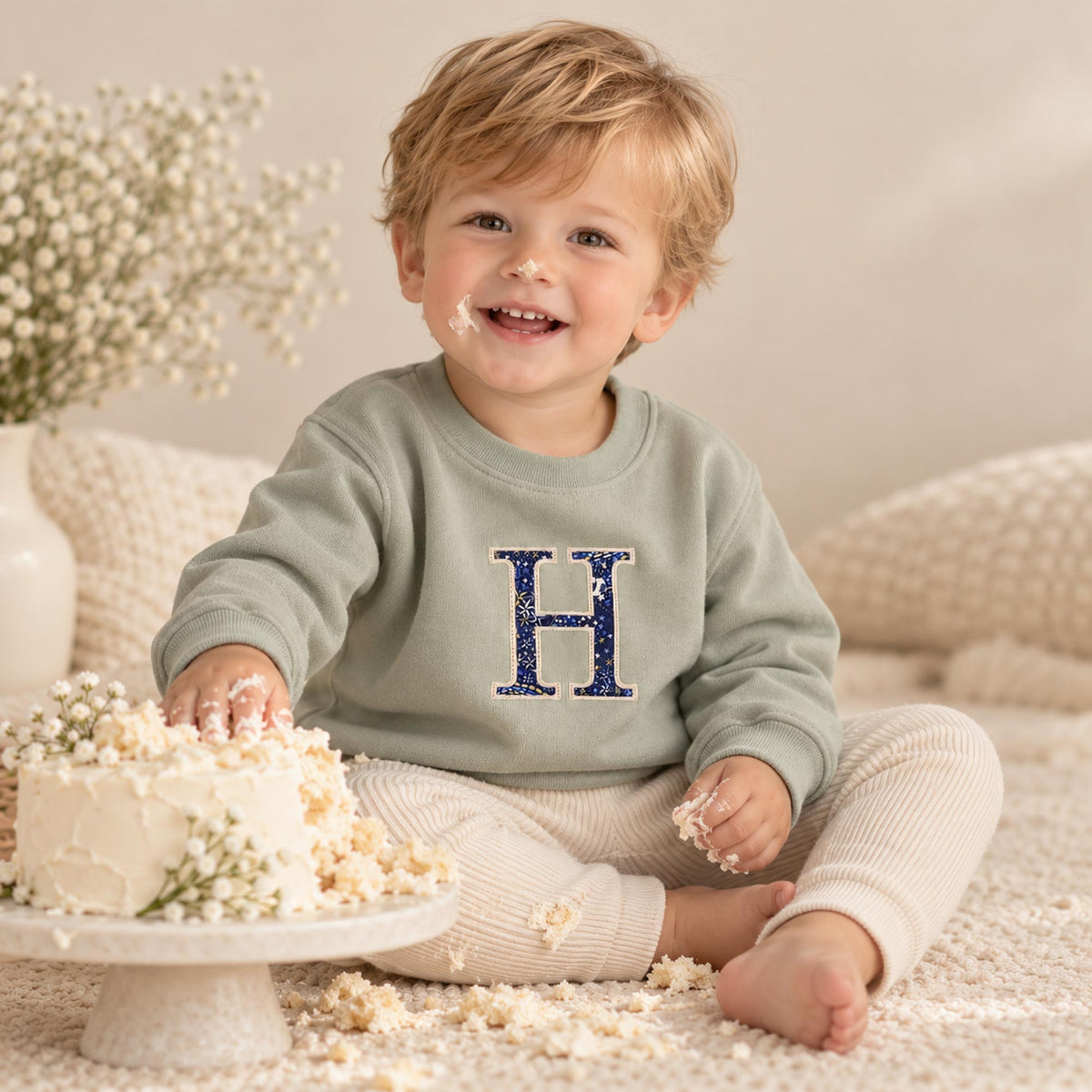 Boy wearing sage personalised Liberty fabric initial jumper, lifestyle photo