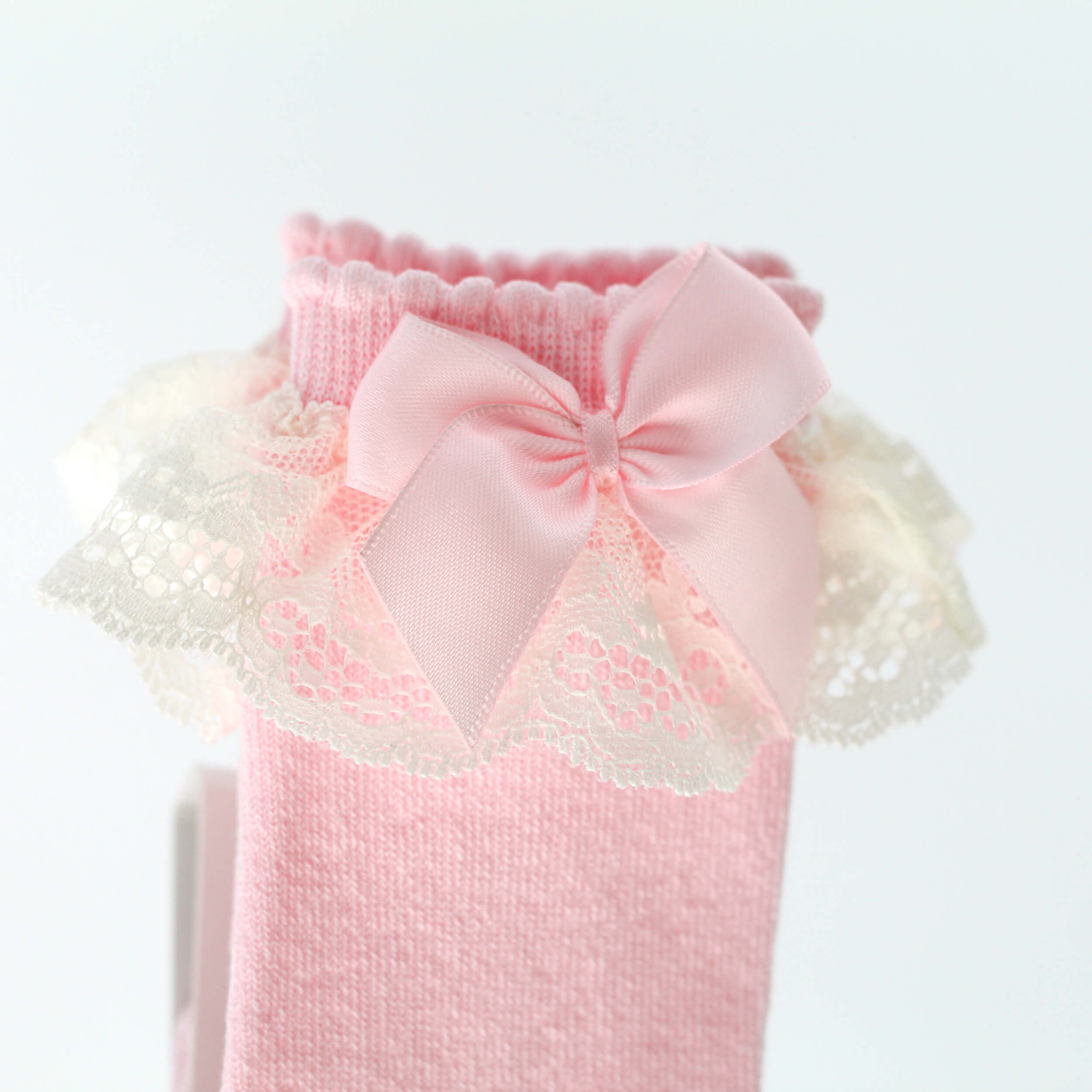 close up of pink spanish baby socks with lace