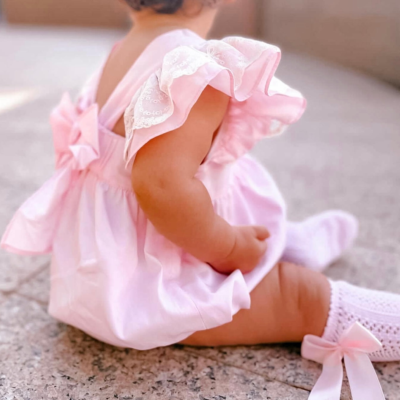 baby wearing pink open back baby girl romper