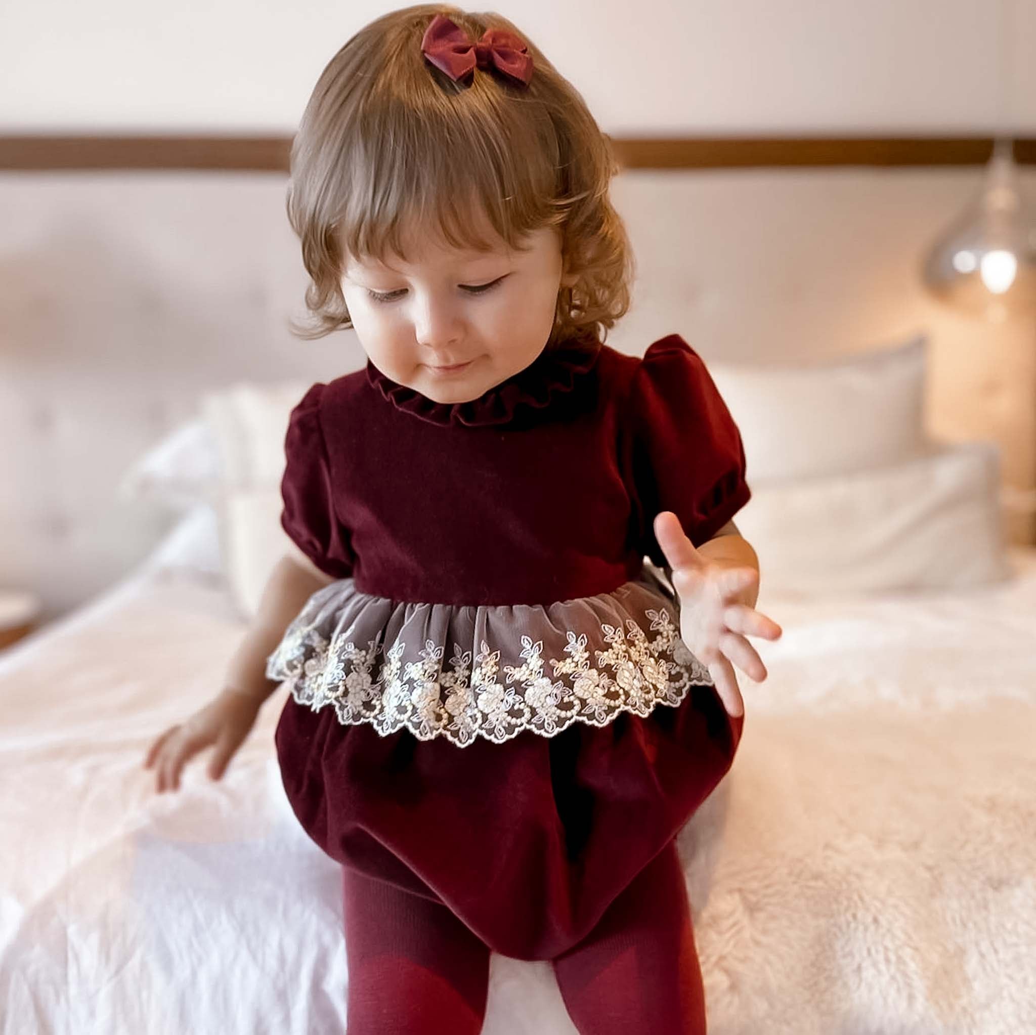 baby wearing burgundy velvet romper
