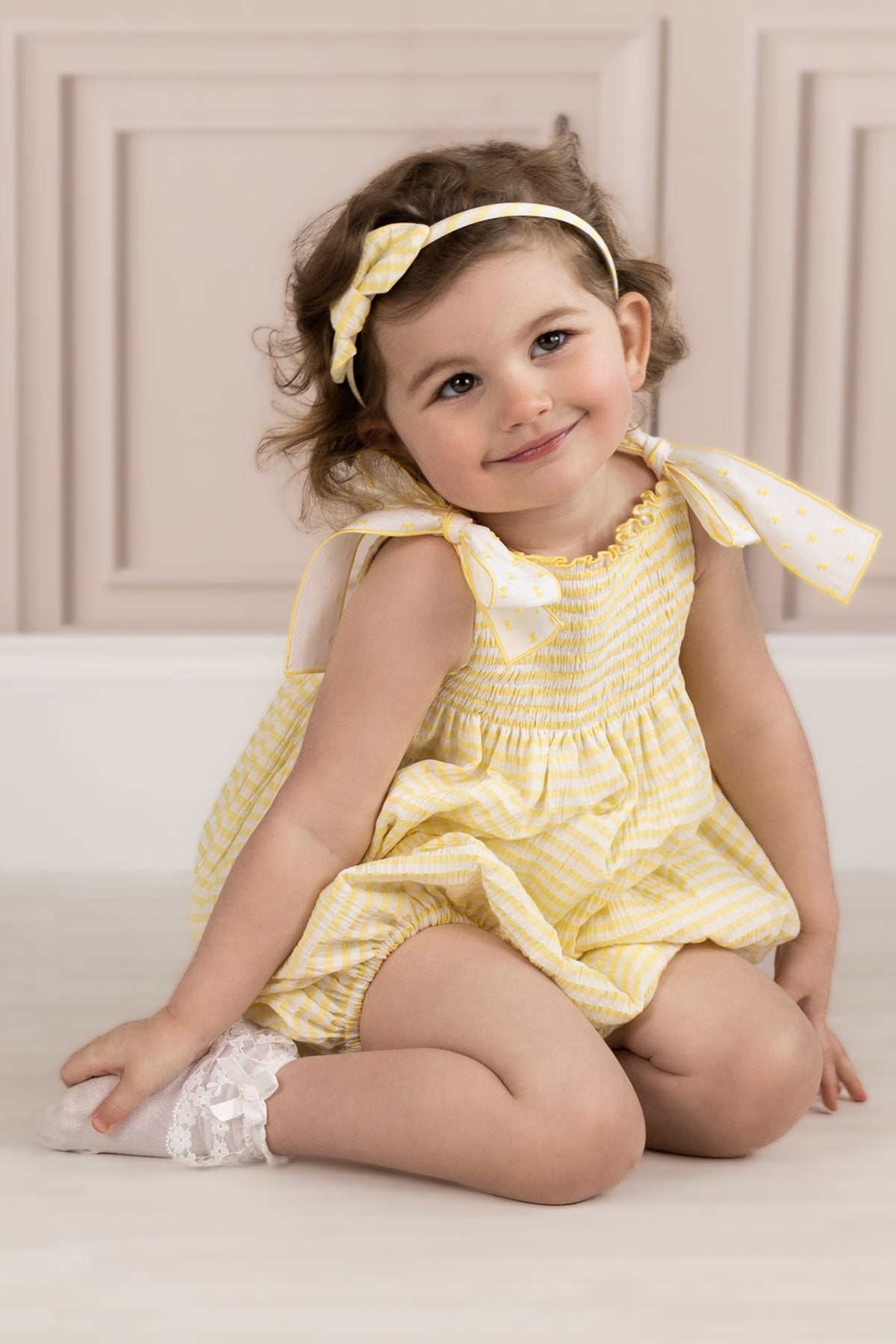 toddler wearing yellow seersucker romper