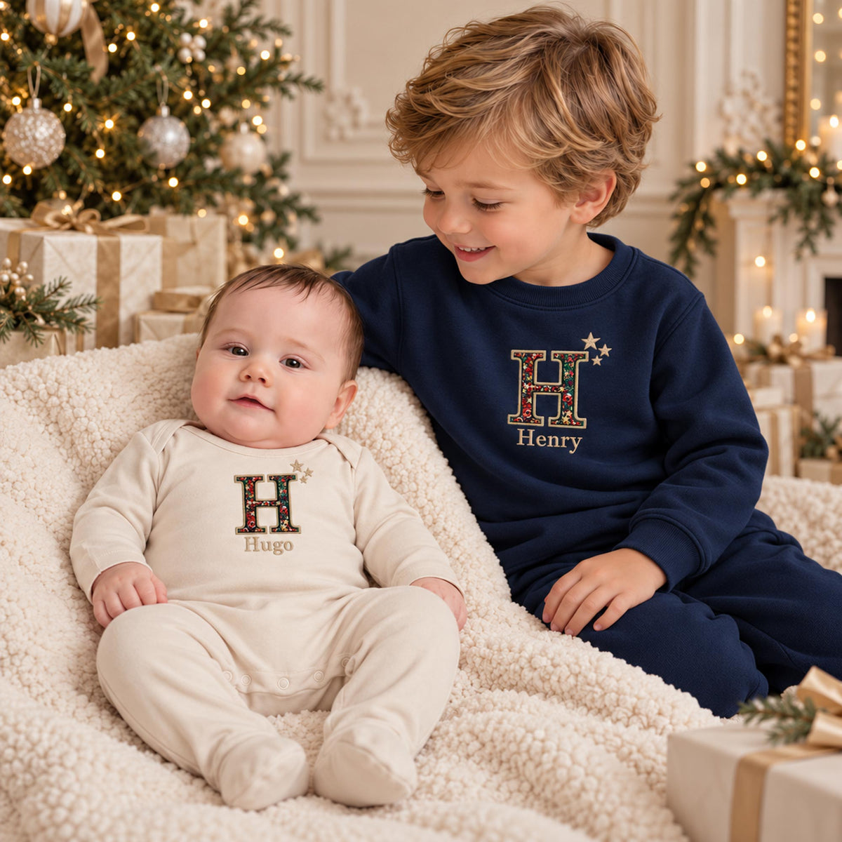 Matching Liberty Christmas initial romper and jumper with embroidered stars, sibling lifestyle photo