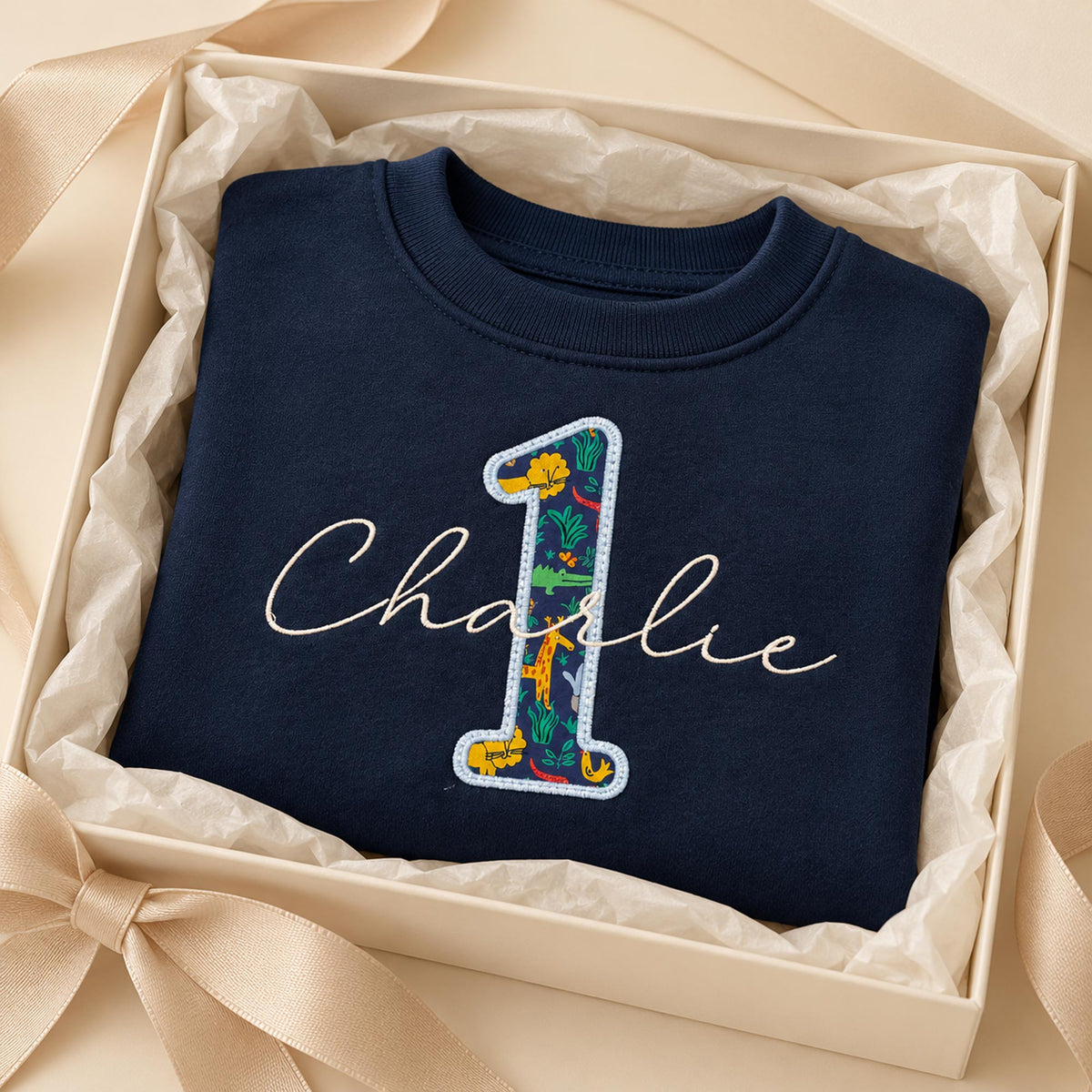 Navy first birthday jumper with script name and Liberty number 1 in Fifi & Finn gift packaging