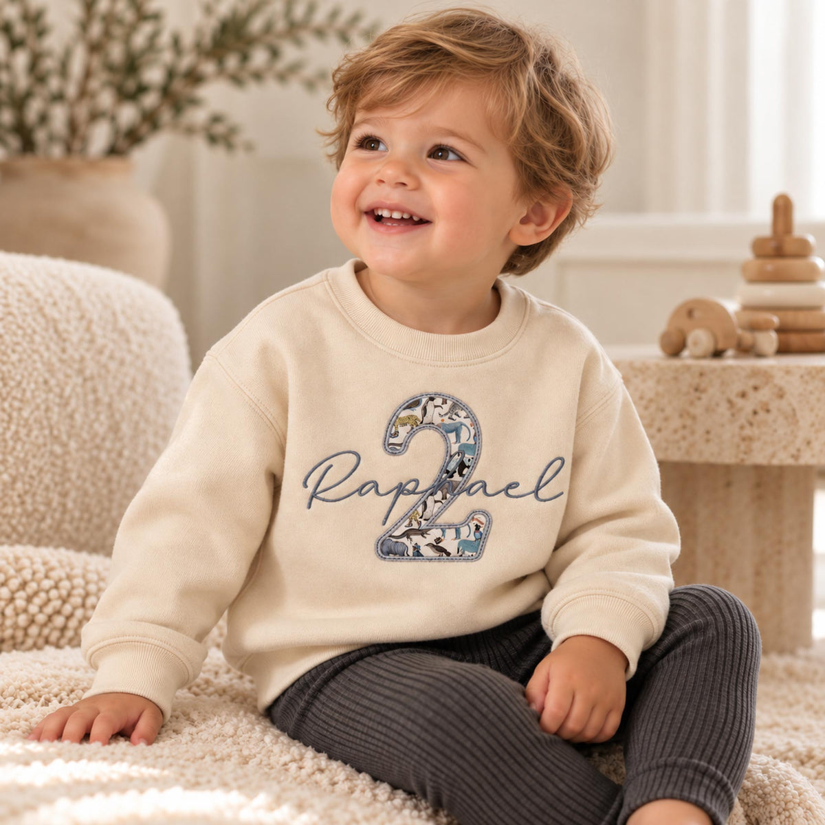 Boy wearing oat 2nd birthday jumper with Liberty fabric number 2 and name in script