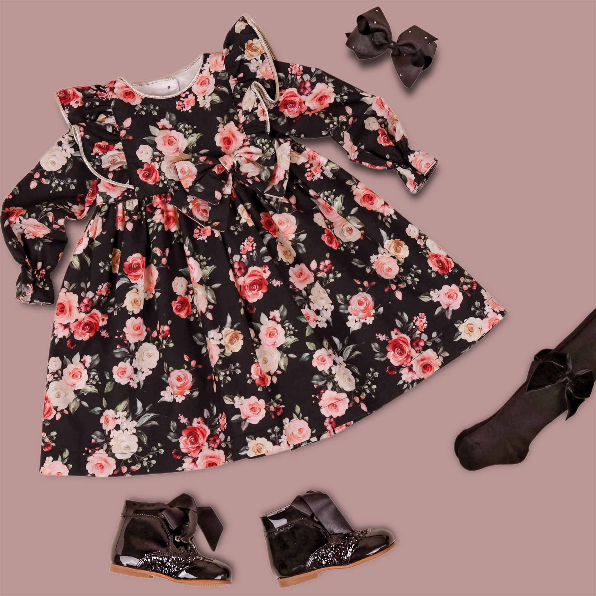black floral girls dress flatlay with patent toddler boots and hair bow