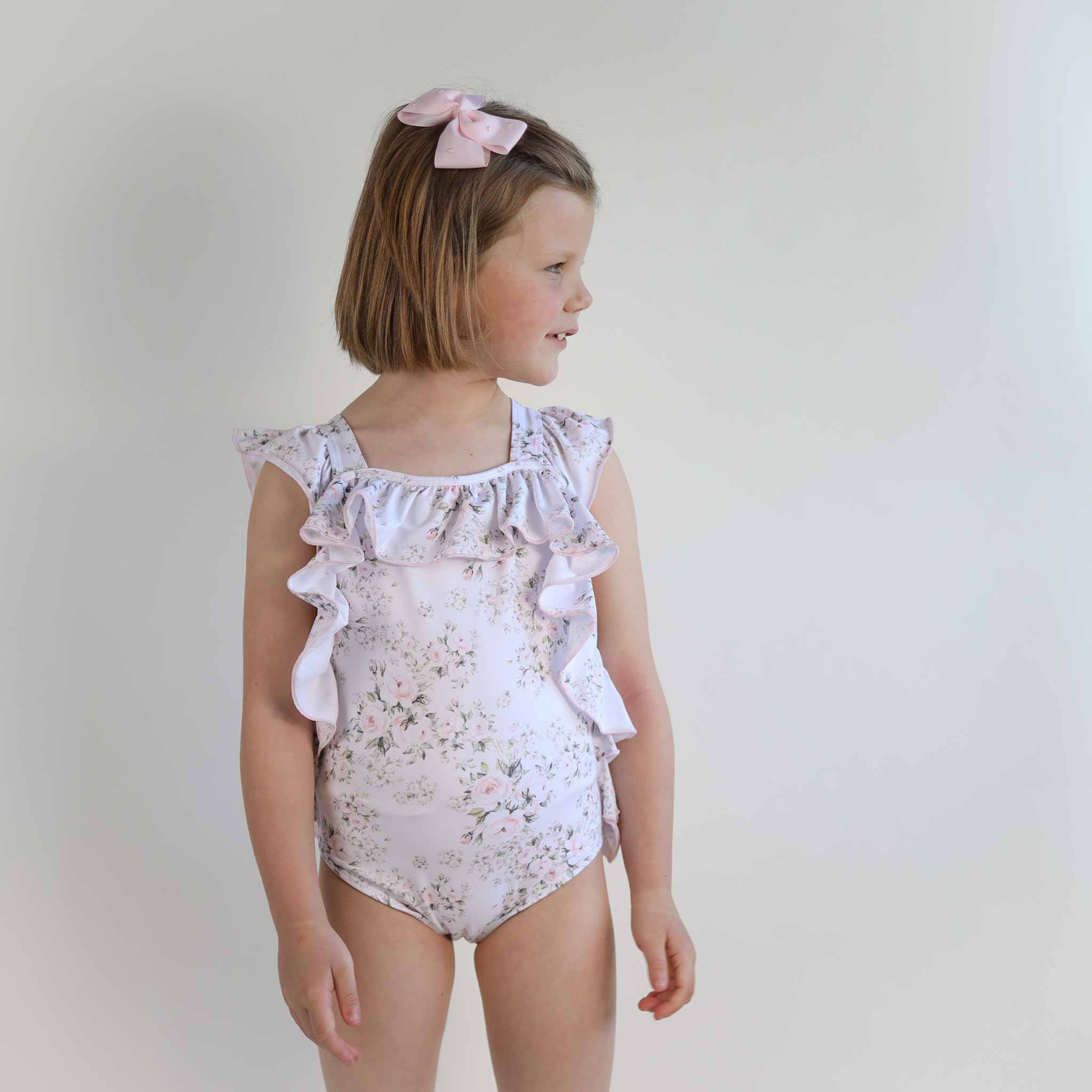 girl wearing white floral swimsuit