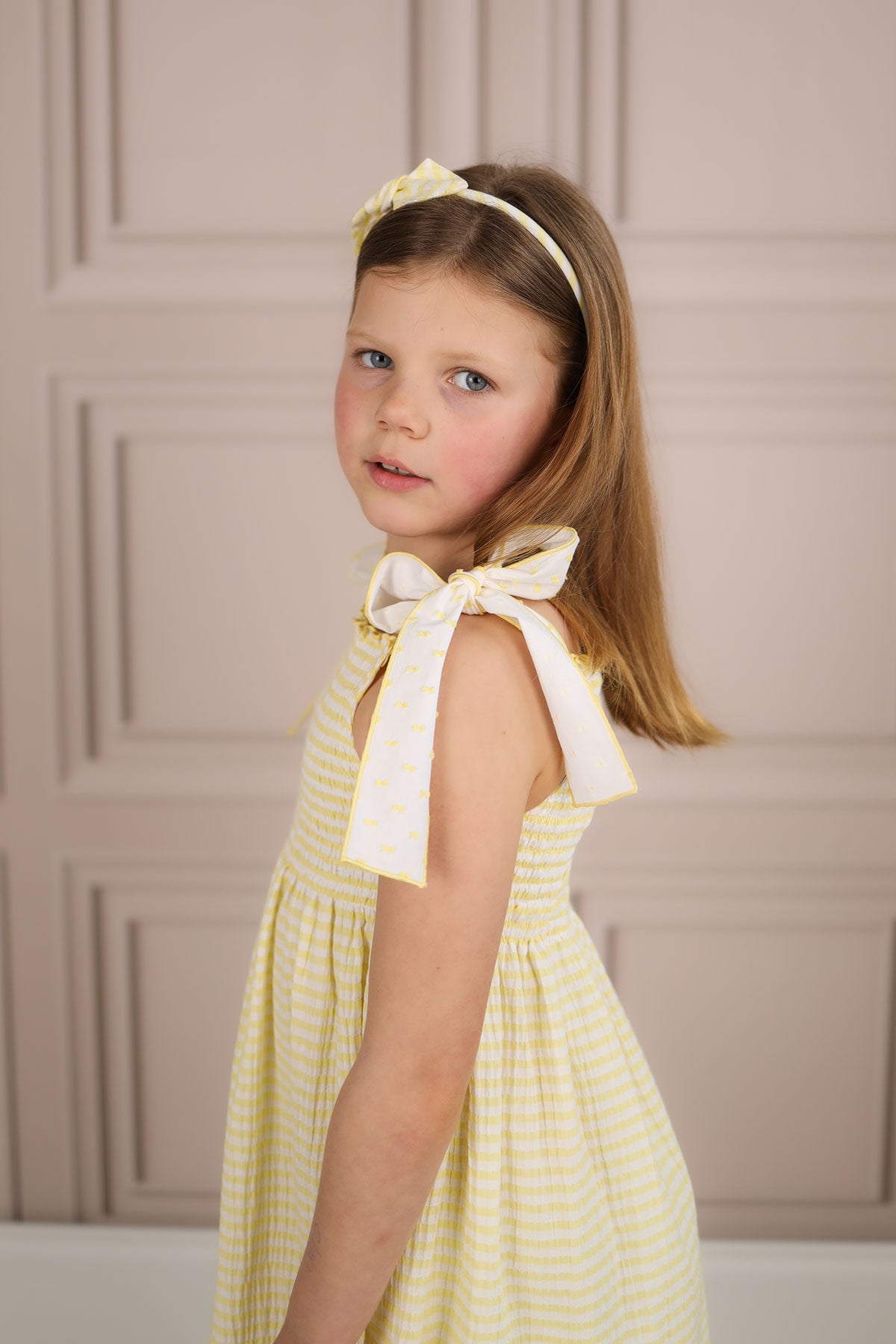 girl wearing yellow striped sun dress